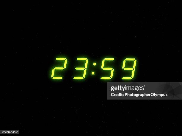 un minuto a mezzanotte - orologio digitale foto e immagini stock