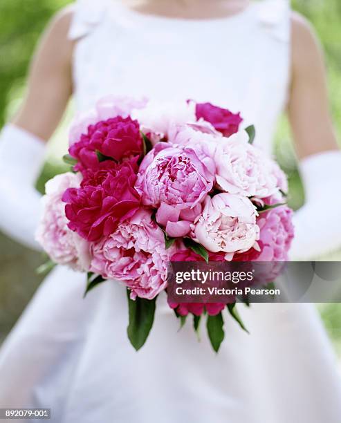 bride holding bouquet of peonies (paeonia sp.), close-up - pink wedding dress stock pictures, royalty-free photos & images