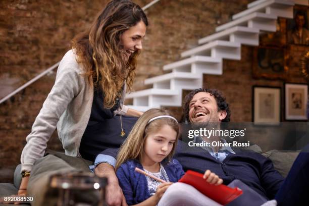 happy family on couch at home - navy blue living room stock pictures, royalty-free photos & images