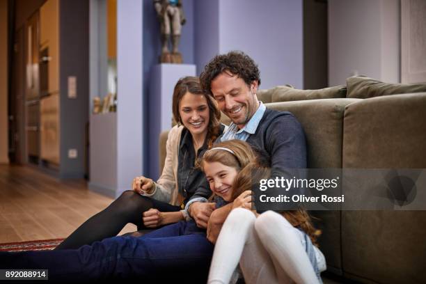 happy family sitting in living room leaning against couch - kids in undies stockfoto's en -beelden