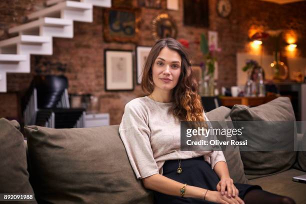 portrait of brunette woman on couch at home - women wearing black stockings stock-fotos und bilder