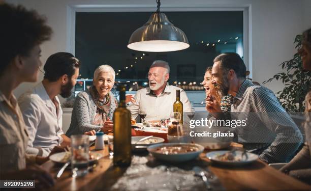 family having dinner on christmas eve. - christmas dinner party stock pictures, royalty-free photos & images