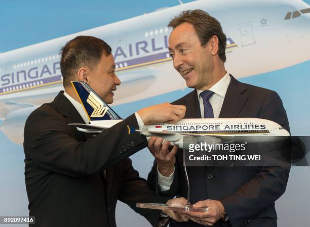 Singapore Airlines chief executive officer Goh Choon Phong presents a SIA plane model to Airbus chief operating officer Fabrice Bregier during the...
