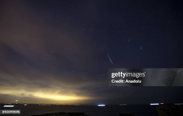 Meteors streak across the night sky during the Geminid meteor shower over Kerpe neighbourhood in Kandira district of Kocaeli, Turkey on December 14,...