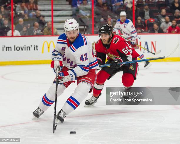 New York Rangers Defenceman Brendan Smith stickhandles the puck against Ottawa Senators Left Wing Mike Hoffman during the third period of the NHL...