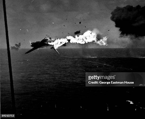 Japanese torpedo bomber explodes in the air after a direct hit by 5 inch shell from the aircraft carrier USS Yorktown as it attempted an unsuccessful...