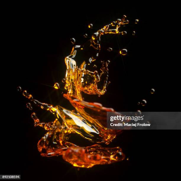 whiskey liquid splash on black background - whisky stock pictures, royalty-free photos & images