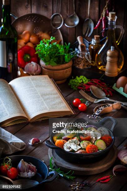 cozinhar legumes saudáveis em uma panela de ferro fundido - cookbook - fotografias e filmes do acervo