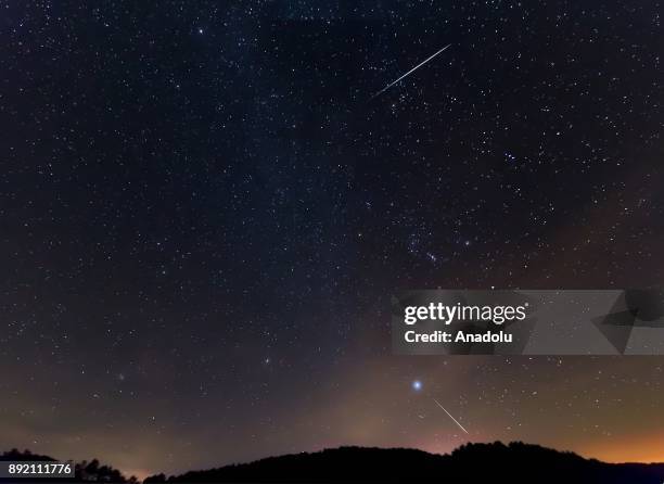 Meteor streaks across the night sky during the Geminid meteor shower over Murat Mountains in Gediz district of Kutahya, Turkey on December 14, 2017....