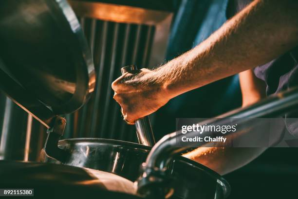 male worker operating machinery in brewery - fábrica de cerveja imagens e fotografias de stock