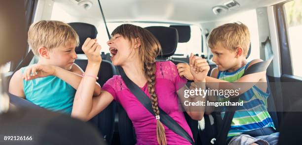 three naughty kids fighting in a car - children fighting stock pictures, royalty-free photos & images