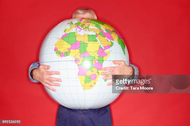 old man holding world globe - world war one stock-fotos und bilder
