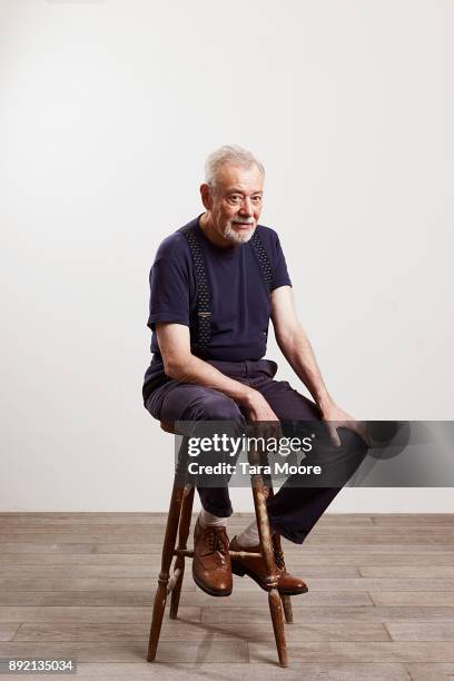 portrait of old man sitting on chair - tabouret photos et images de collection