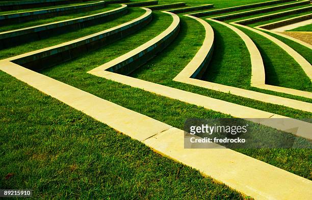 symmetrical green grass lawn with rows of steps at a park - amphitheatre stock pictures, royalty-free photos & images