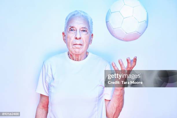older man throwing up ball - ball werfen stock-fotos und bilder