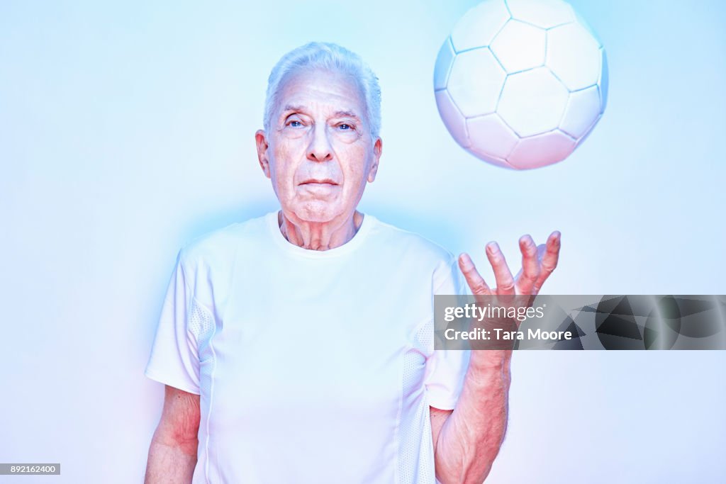 Older man throwing up ball