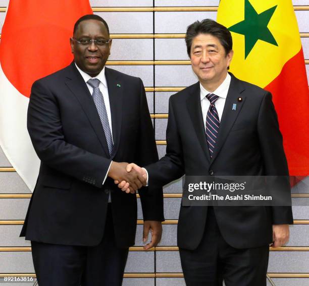 Senegalese President Macky Sall shakes hands with Japanese Prime Minister Shinzo Abe prior to their meeting at the prime minister's official...