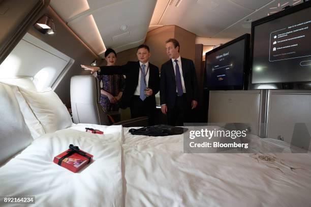 Goh Choon Phong, chief executive officer of Singapore Airlines Ltd., center, and Fabrice Bregier, chief operating officer of Airbus SE, look at a...