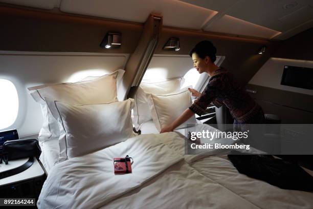 Flight attendant arranges a pillow of a bed in a suite of a Singapore Airlines Ltd. Airbus SE A380 aircraft with refitted cabins during a media tour...