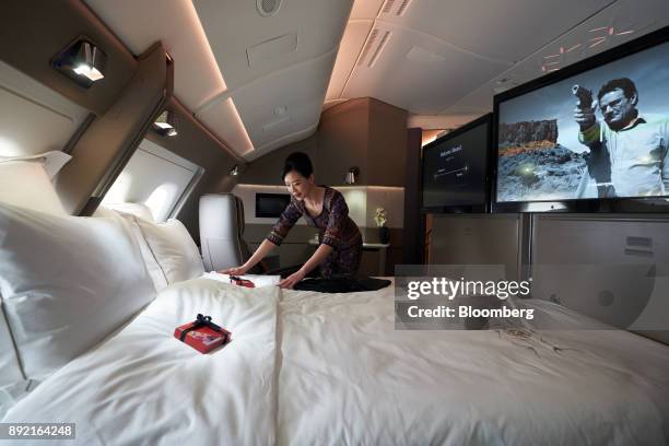 Flight attendant arranges the bed in a suite of a Singapore Airlines Ltd. Airbus SE A380 aircraft with refitted cabins during a media tour at Changi...