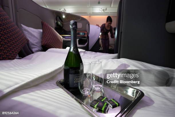 Champagne sits on a business class seat of a Singapore Airlines Ltd. Airbus SE A380 aircraft with refitted cabins during a media tour at Changi...
