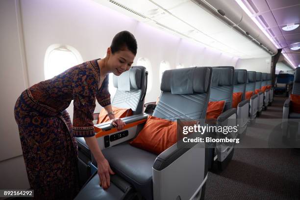 Flight attendant arranges a premium class seat of a Singapore Airlines Ltd. Airbus SE A380 aircraft with refitted cabins during a media tour at...