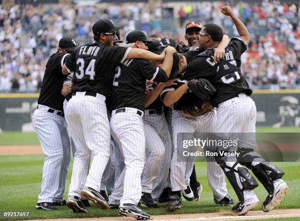 Mark Buehrle of the Chicago White Sox is mobbed by teammates after Buehrle recorded the 18th perfect game in major league history against the Tampa...