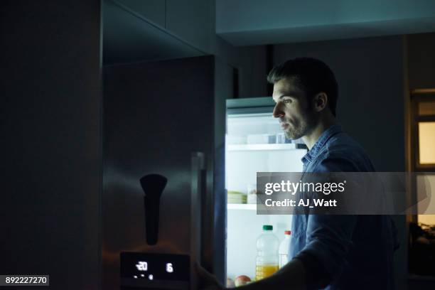 who can resist a midnight snack? - opening fridge night stock pictures, royalty-free photos & images