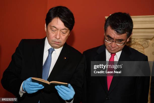 Japanese Defence Minister Itsunori Onodera and Japan's Foreign Minister Taro Kono examine a selection of historical naval artifacts in the Queen's...