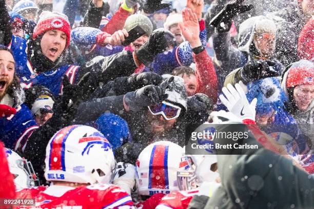 Fans celebrate above players after LeSean McCoy of the Buffalo Bills scores the game winning touchdown in overtime against the Indianapolis Colts at...