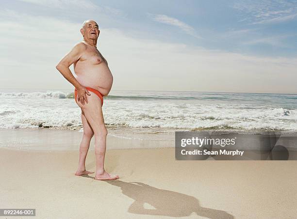 mature man wearing swimsuit on beach - fat guy on beach fotografías e imágenes de stock