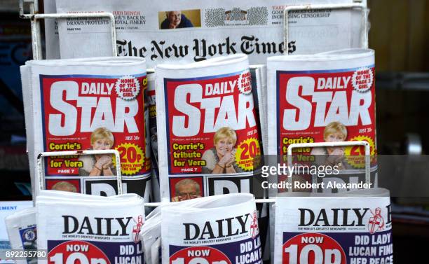Newsstand rack in London, England, features daily newspapers, including The New York Times from the U.S. And the Daily Star and the Daily Express,...