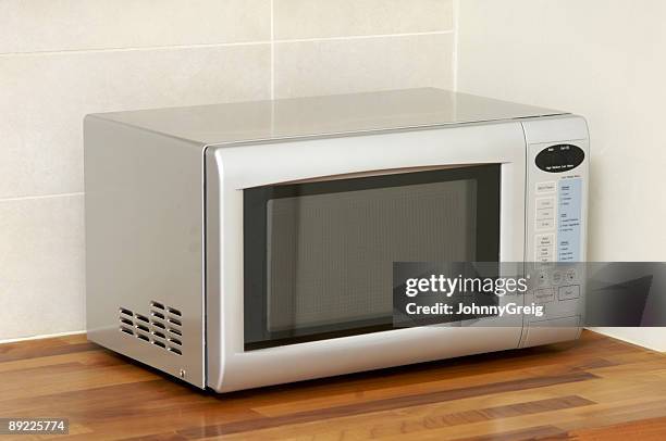 microwave oven on kitchen worktop - microwave oven stock pictures, royalty-free photos & images