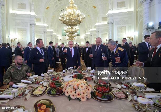Russian President Vladimir Putin toasts with attendees at a reception marking Russia's Heroes of the Fatherland Day at the Kremlin in Moscow on...
