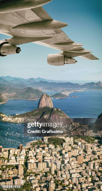brasilien rio de janeiro kommerziellen flugzeug fliegt über die guanabara-bucht mit zuckerhut - sugar loaf stock-fotos und bilder