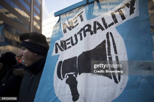 Demonstrator opposed to the roll back of net neutrality rules holds a sign outside the Federal Communications Commission headquarters ahead of a open...
