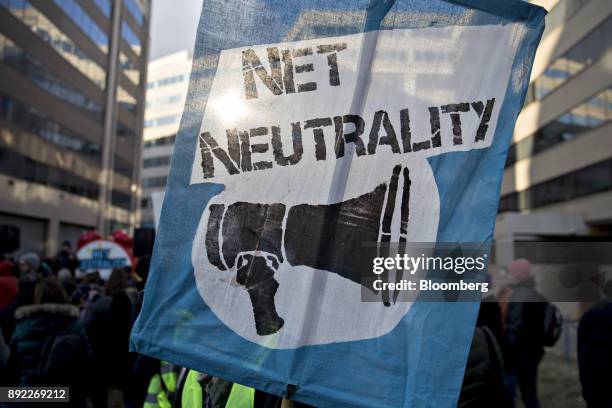 Demonstrator opposed to the roll back of net neutrality rules holds a sign outside the Federal Communications Commission headquarters ahead of a open...