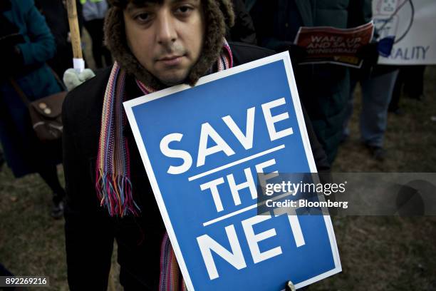 Demonstrator opposed to the roll back of net neutrality rules holds a "Save The Net" sign outside the Federal Communications Commission headquarters...