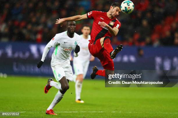 Lucas Alario of Bayer 04 Leverkusen gets past the tackle from Lamine Sane during the Bundesliga match between Bayer 04 Leverkusen and SV Werder...