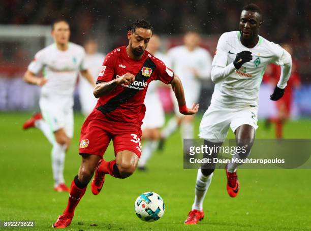 Karim Bellarabi of Bayer 04 Leverkusen gets past the tackle from Lamine Sane of Werder Bremen during the Bundesliga match between Bayer 04 Leverkusen...
