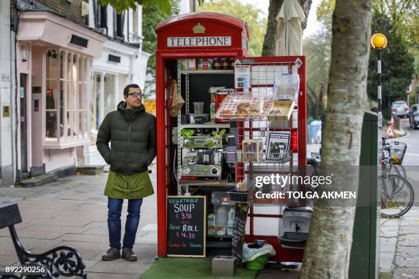 Umar Khalid poses outside the red telephone box from which he runs a coffee shop in Hampstead Heath, north London on October 20, 2017. - Facing...
