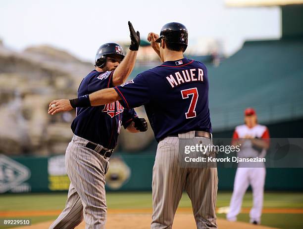 Jason Kubel of the Minnesotta Twins is congratulated by teammate Joe Maur after hitting a two-run home run off pitcher Jered Weaver of the Los...