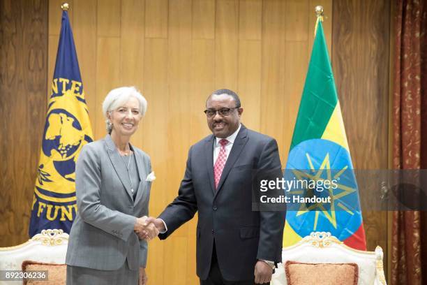 In this handout image provided by the International Monetary Fund, International Monetary Fund Managing Director Christine Lagarde shakes hands with...