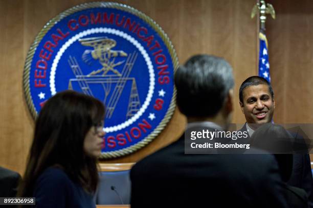 Ajit Pai, chairman of the Federal Communications Commission , right, greets presenters during an open commission meeting in Washington, D.C., U.S.,...