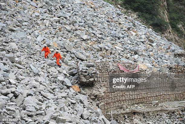 Rescuers make their way to the landslide site in Kangding, in southwest China's Sichuan province on July 23, 2009. Four people were killed and 53...