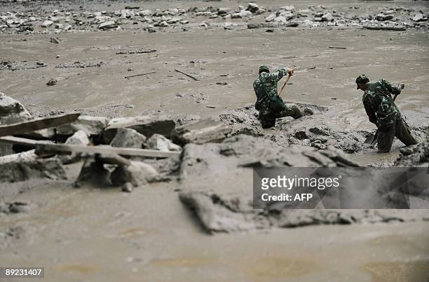 Rescuers search through the mud near the landslide site in Kangding, in southwest China's Sichuan province on July 23, 2009. Four people were killed...