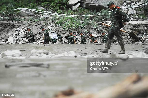 Rescuers make their way to the landslide site in Kangding, in southwest China's Sichuan province on July 23, 2009. Four people were killed and 53...