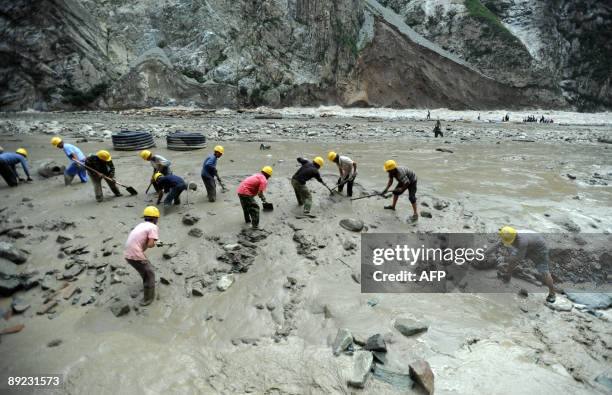 Rescuers search through mud looking for victims at the landslide site in Kangding, in southwest China's Sichuan province on July 23, 2009. Four...