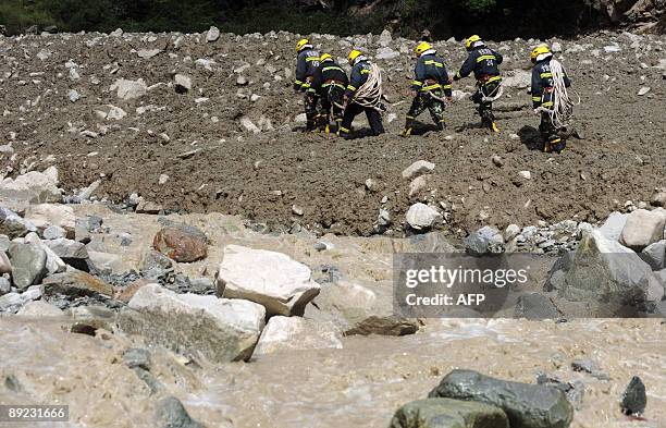 Rescuers make their way to the landslide site in Kangding, in southwest China's Sichuan province on July 23, 2009. Four people were killed and 53...