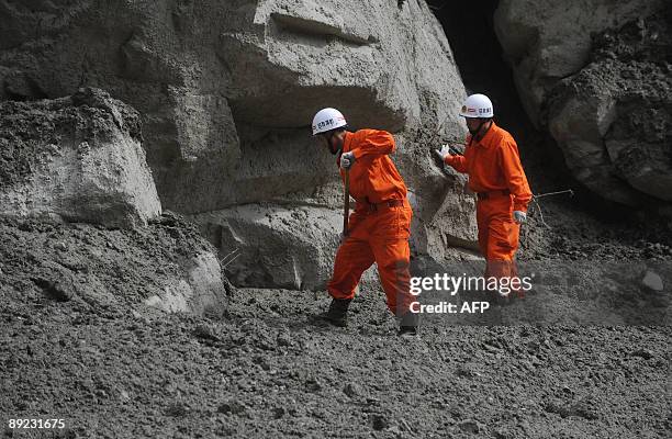 Rescuers search through mud looking for victims at the landslide site in Kangding, in southwest China's Sichuan province on July 23, 2009. Four...